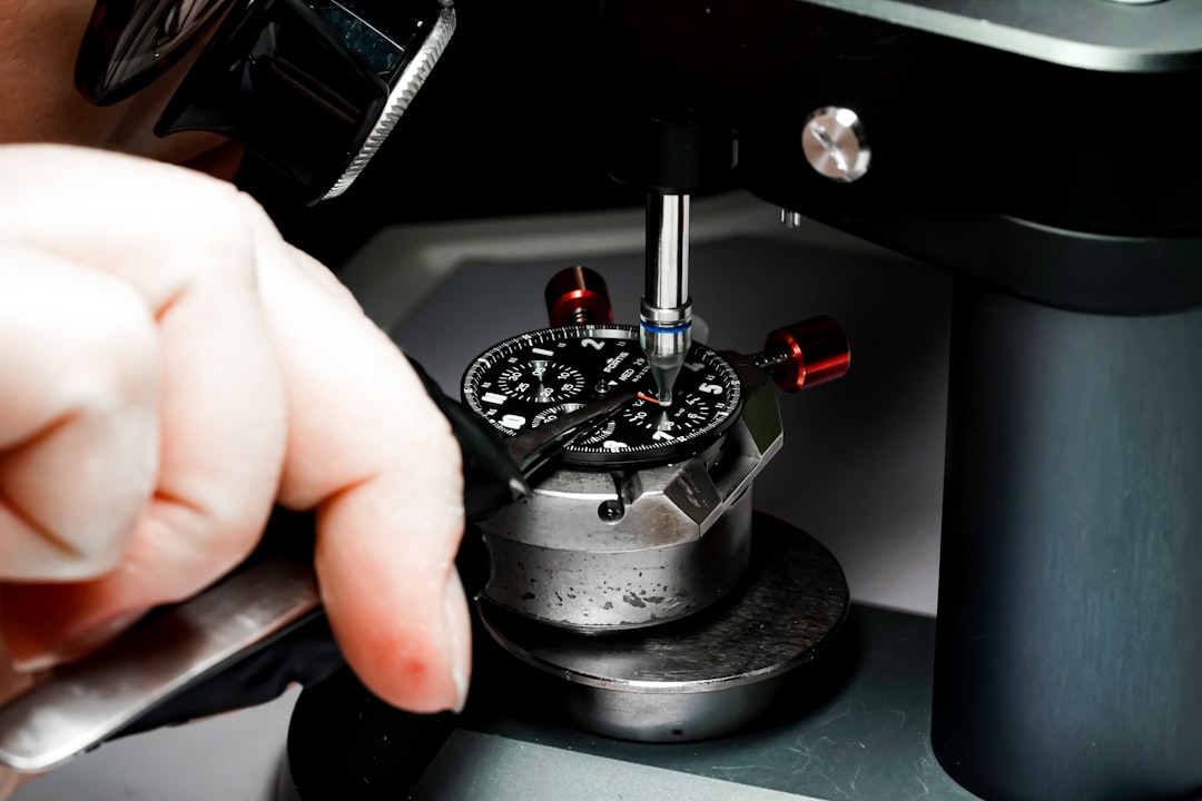 a person is working on a watch in a machine