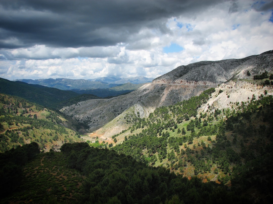 a view of a valley and mountains under a cloudy sky