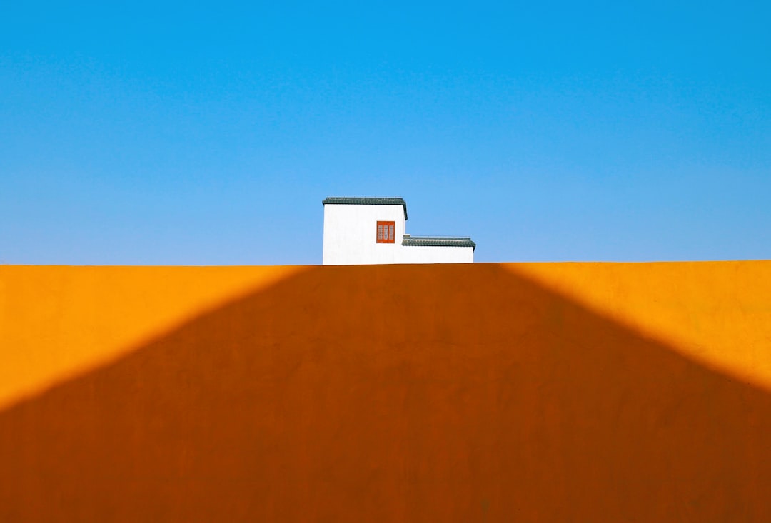 a house on top of a hill with a blue sky in the background