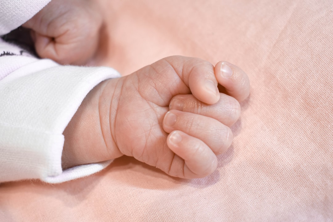 A close up of a baby laying on a bed