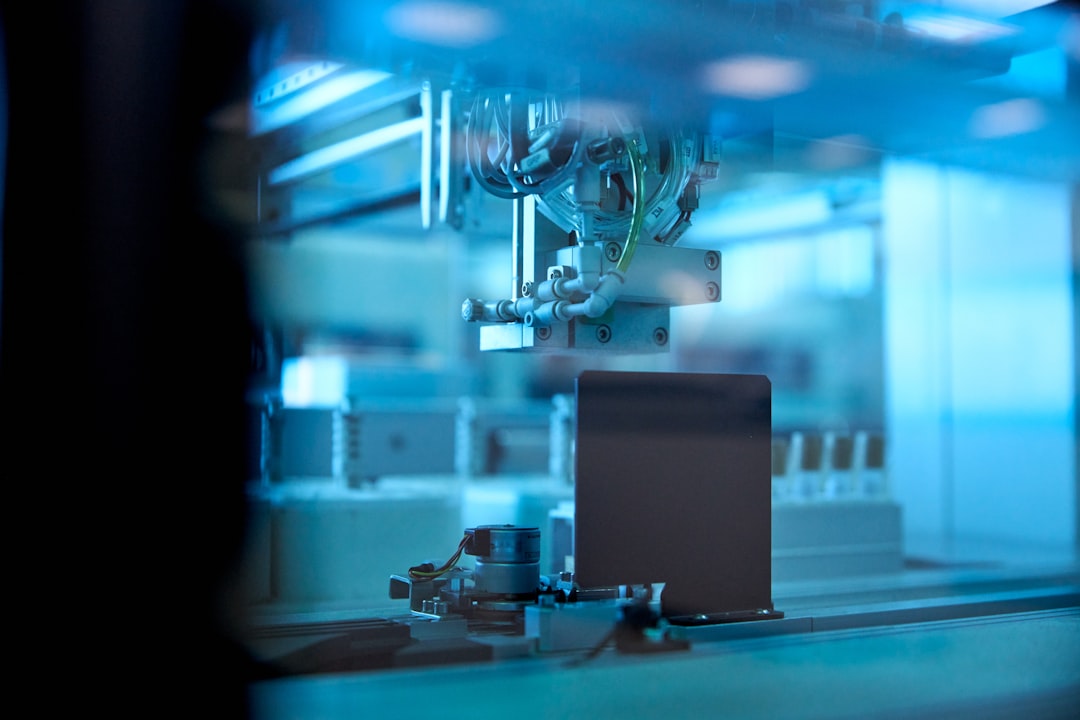 industrial robotic arm in blue lit factory