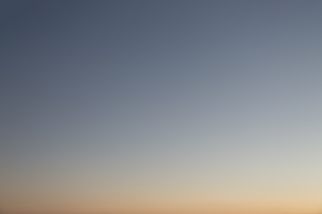 a plane flying in the sky at sunset