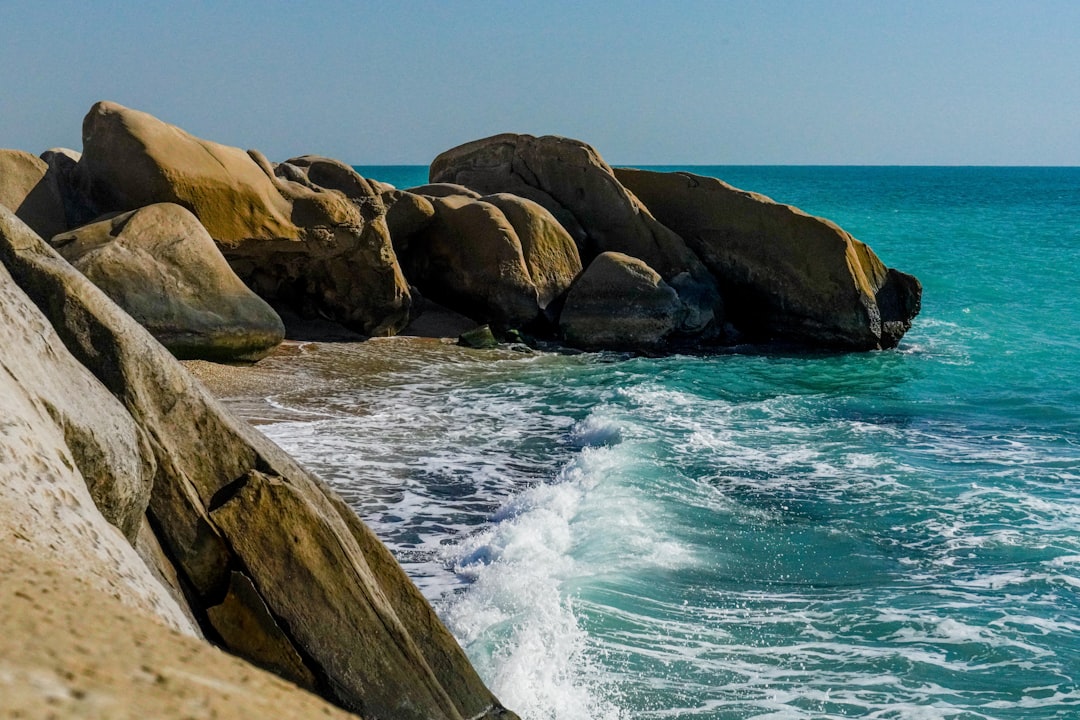 a rocky beach with a body of water next to it