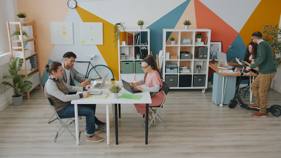 People working at desks in a colorful office with geometric wall patterns