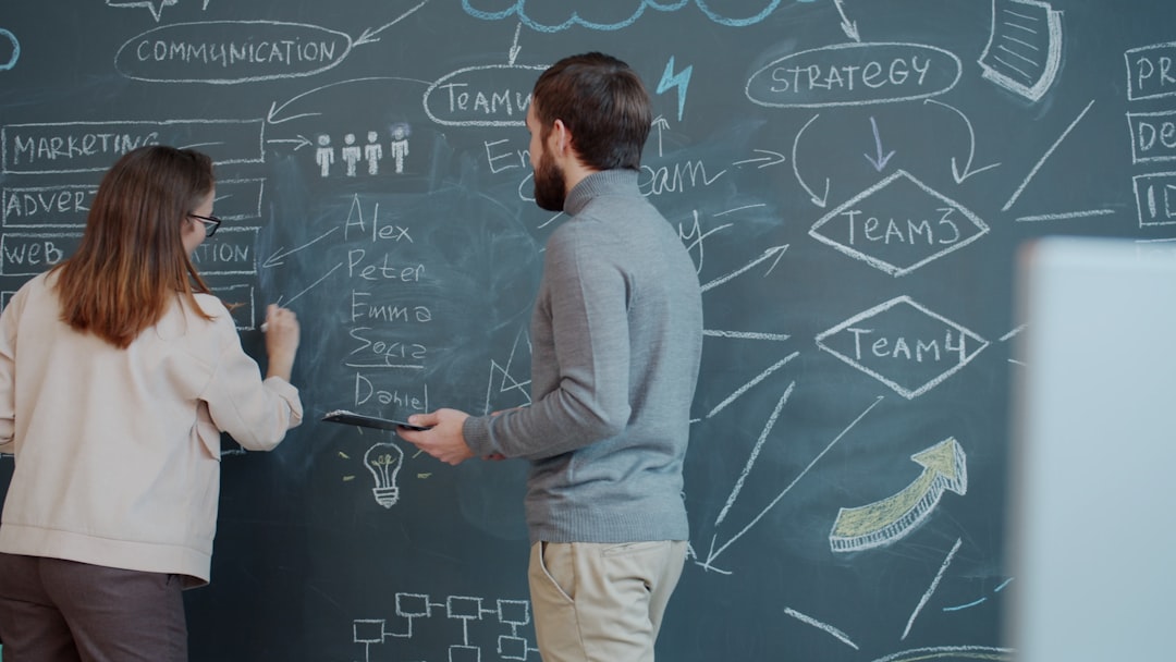 Two people planning on a chalkboard with diagrams