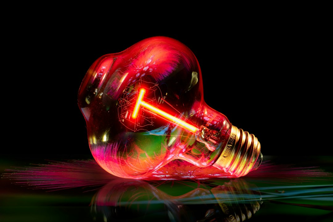 A glowing red light bulb with a bright filament
