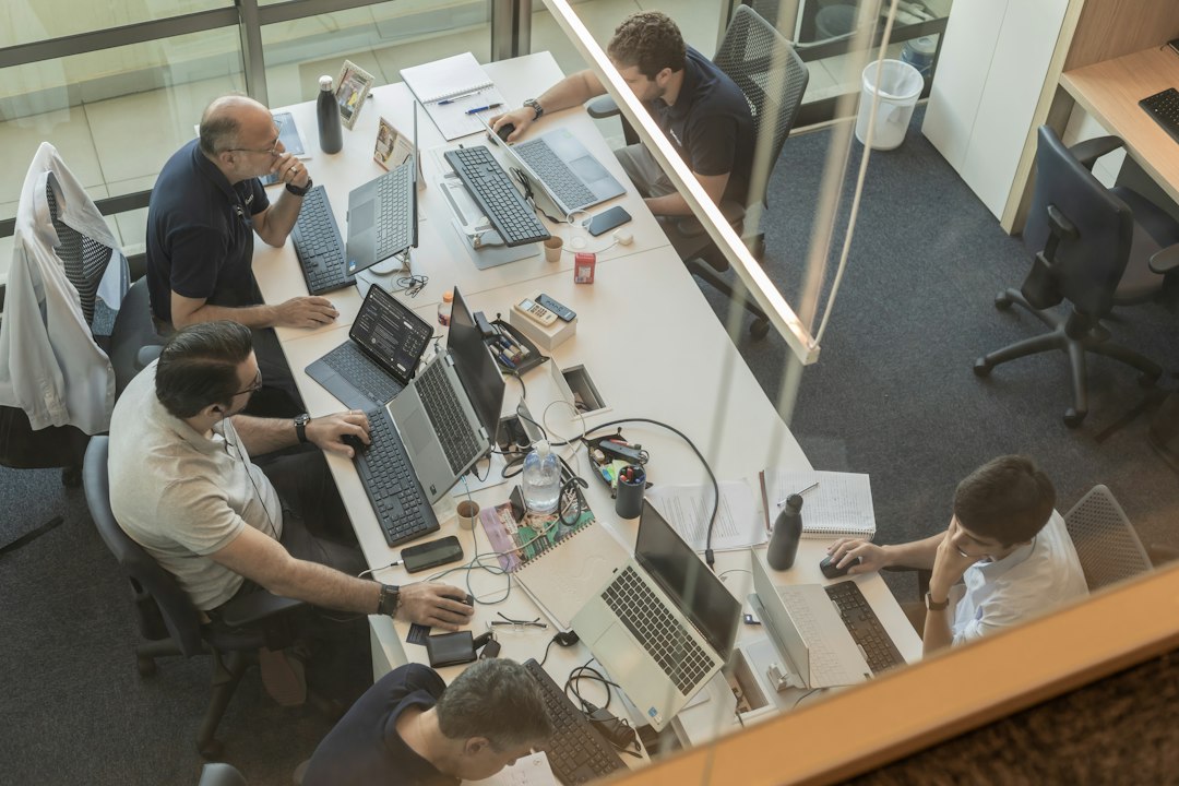 Four people working at desks in a modern office