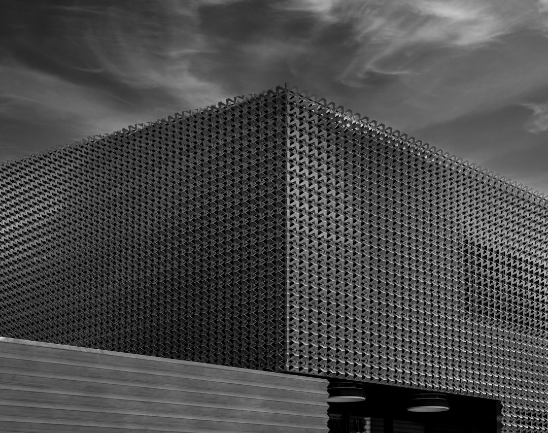 grayscale photo of building under cloudy sky